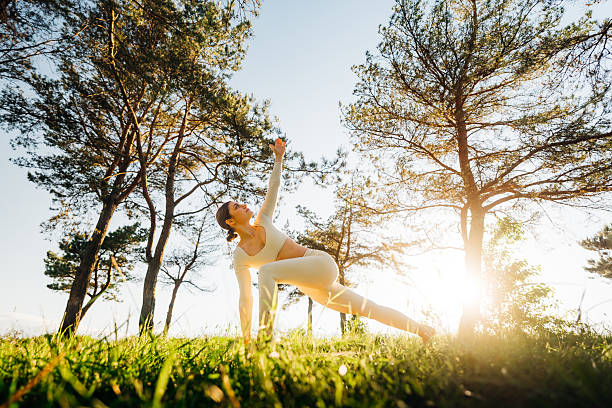 Woman performing a gentle yoga flow outdoors in natural morning light
